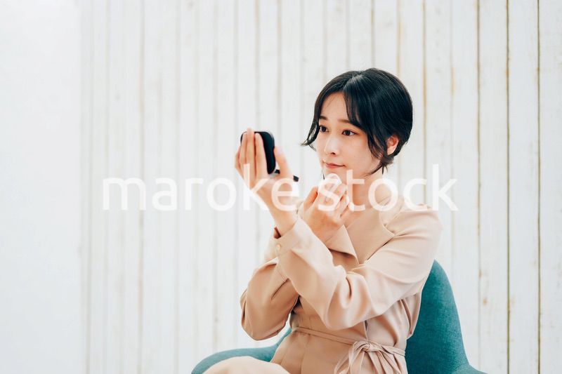 笑顔でメイクをする若い女性