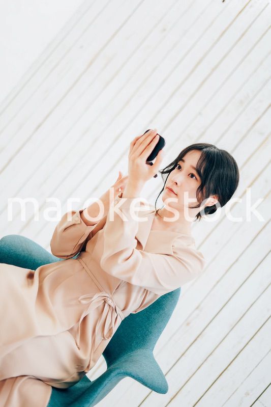 笑顔でメイクをする若い女性