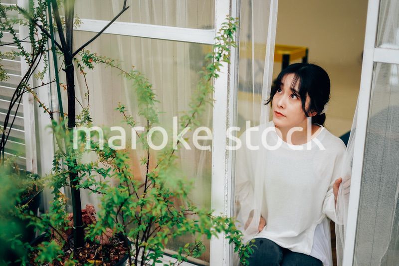 外の天気を確認する若い女性