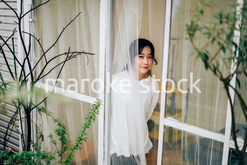 外の天気を確認する若い女性