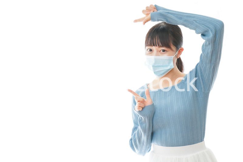 ポイントを指差すマスクを付けた若い女性