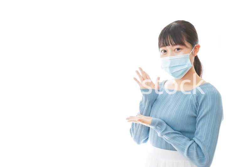 ポイントを指差すマスクを付けた若い女性