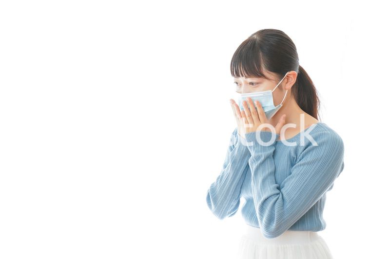 咳の症状が出るマスクを付けた若い女性