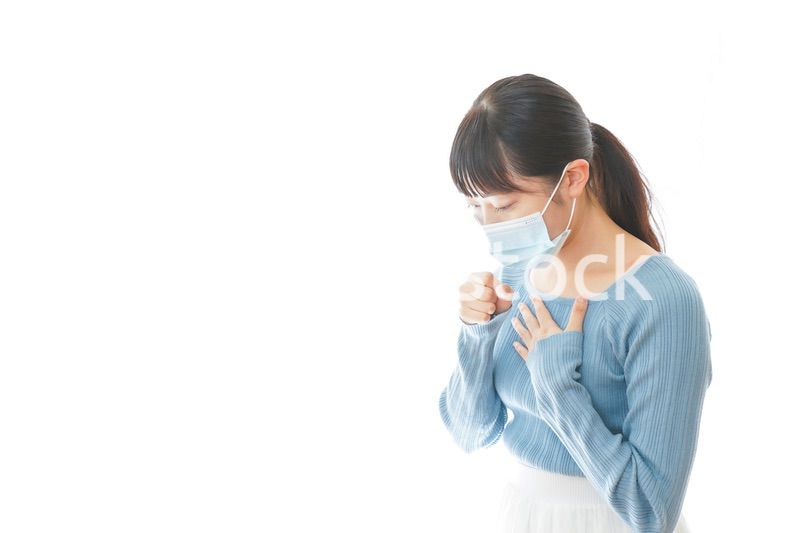 咳の症状が出るマスクを付けた若い女性