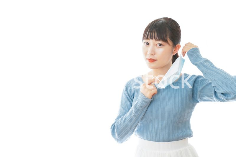 マスクを付けるカジュアルな服装の女性