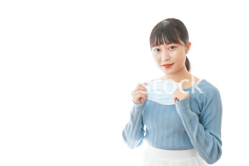 マスクを付けるカジュアルな服装の女性