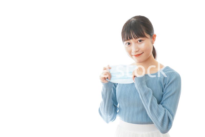 マスクを付けるカジュアルな服装の女性