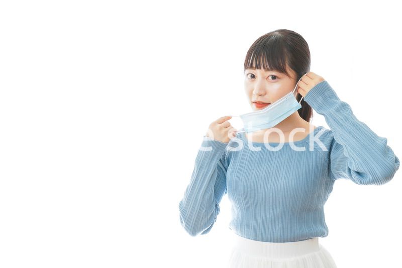 マスクを付けるカジュアルな服装の女性