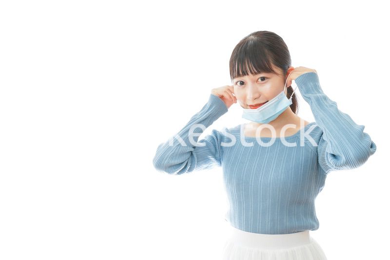 マスクを付けるカジュアルな服装の女性