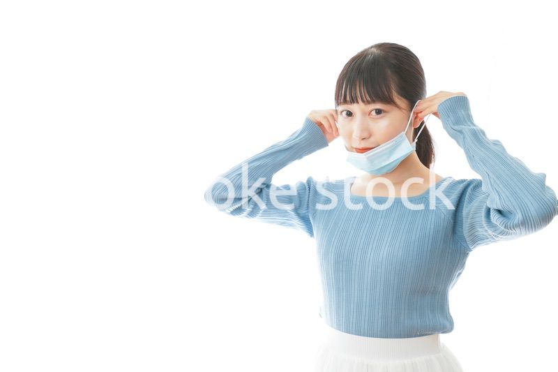 マスクを付けるカジュアルな服装の女性