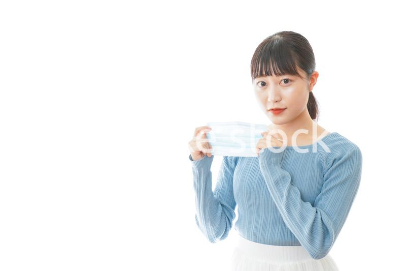 マスクを付けるカジュアルな服装の女性