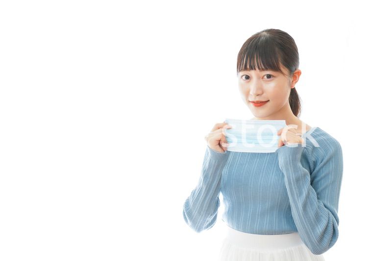 マスクを付けるカジュアルな服装の女性