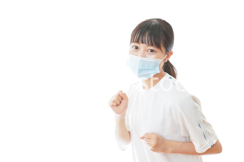 マスクをつけてランニングをする若い学生