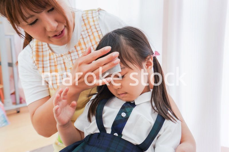 体調不良の子供と保育士