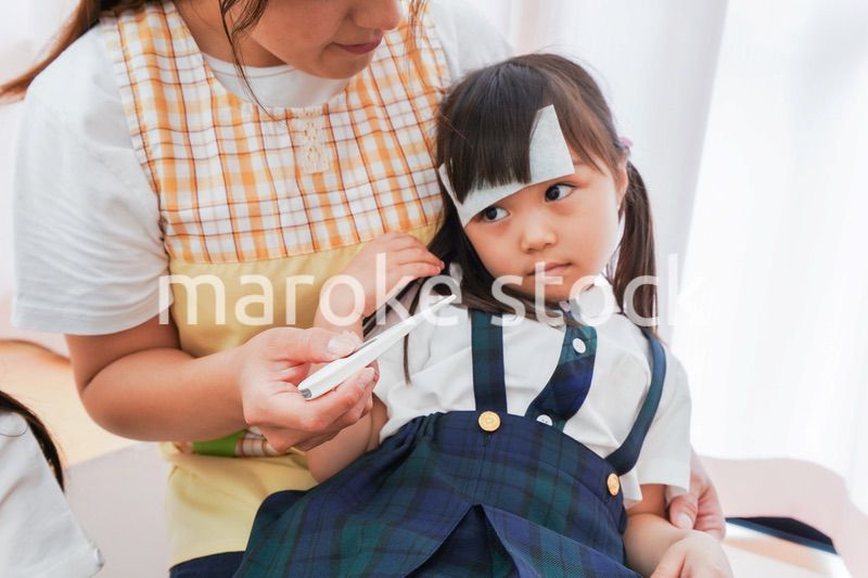 体調不良の子供と保育士
