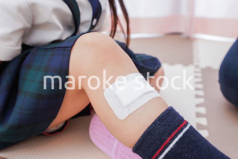 子供の怪我の手当をする保育士