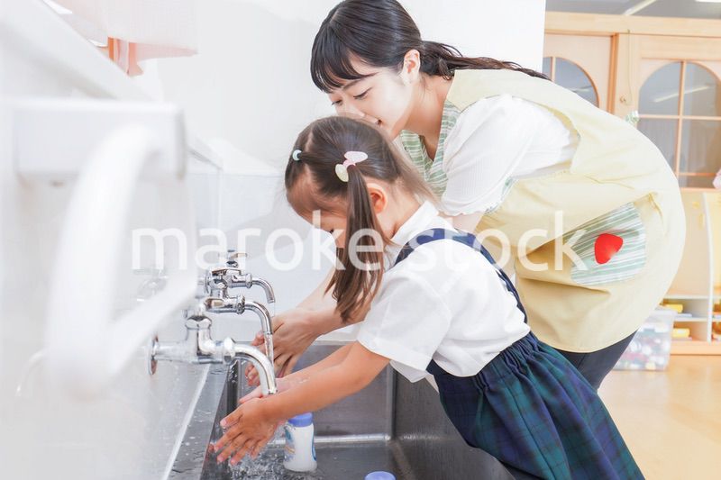 手を洗う子供と保育士
