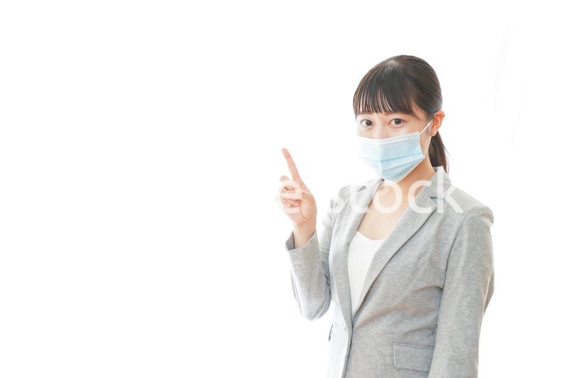 マスクをして指をさす若いビジネスパーソン