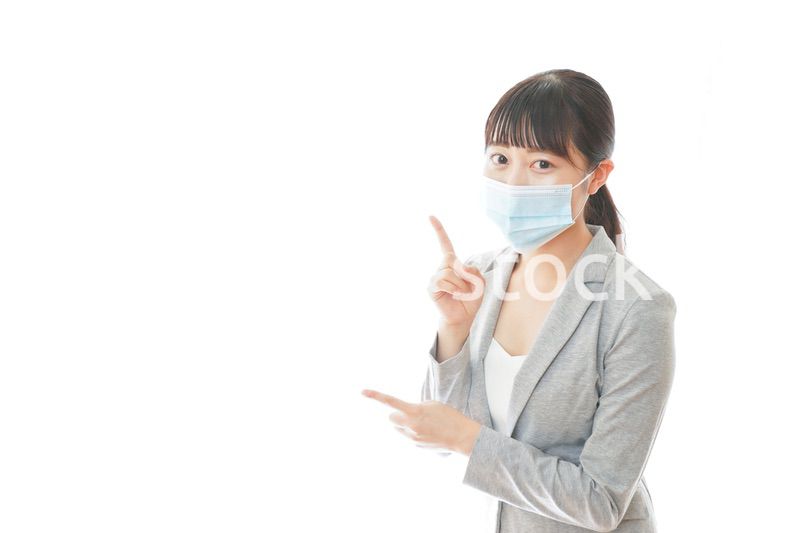 マスクをして指をさす若いビジネスパーソン