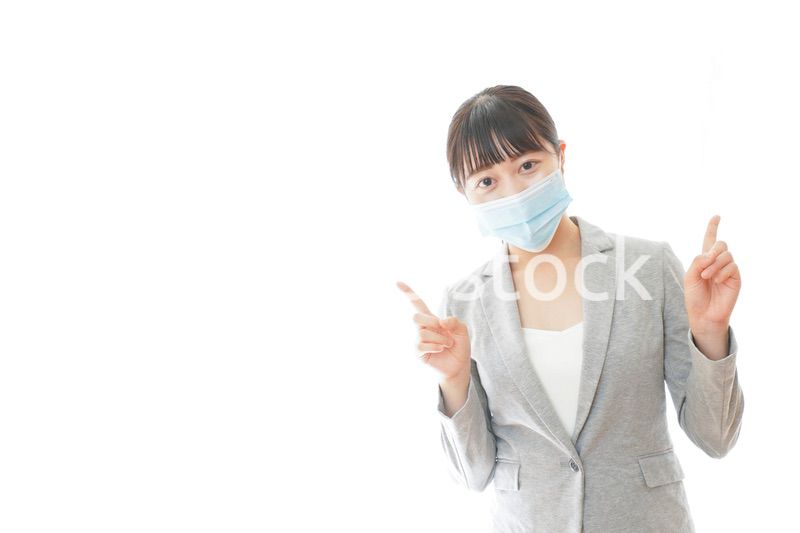 マスクをして指をさす若いビジネスパーソン