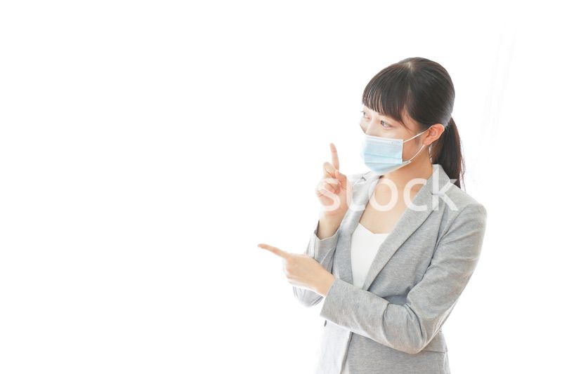 マスクをして指をさす若いビジネスパーソン