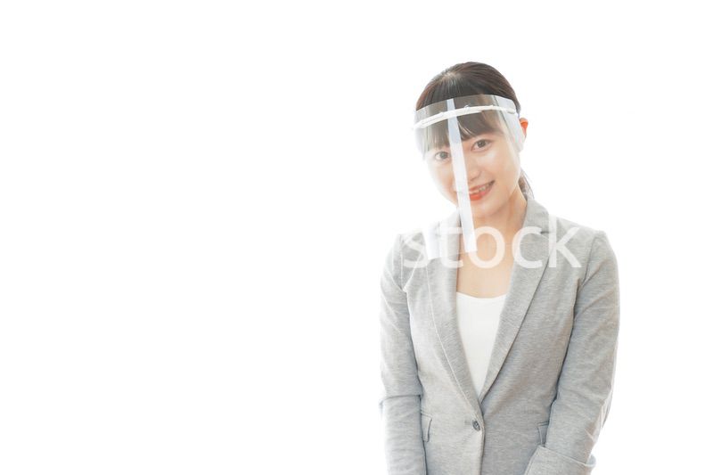 フェイスシールドをして働く若いビジネスウーマン