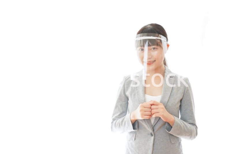 フェイスシールドをして働く若いビジネスウーマン