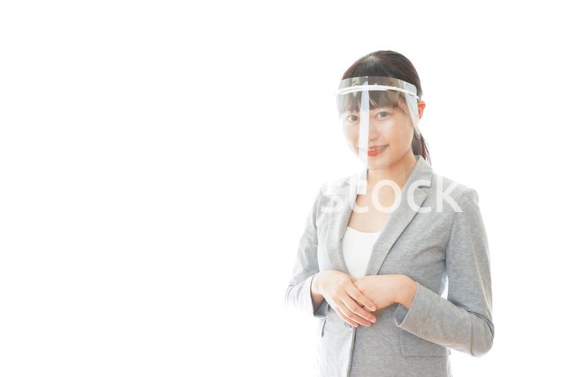 フェイスシールドをして働く若いビジネスウーマン