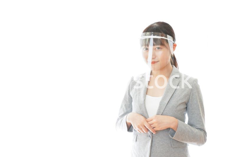 フェイスシールドをして働く若いビジネスウーマン