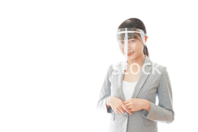 フェイスシールドをして働く若いビジネスウーマン