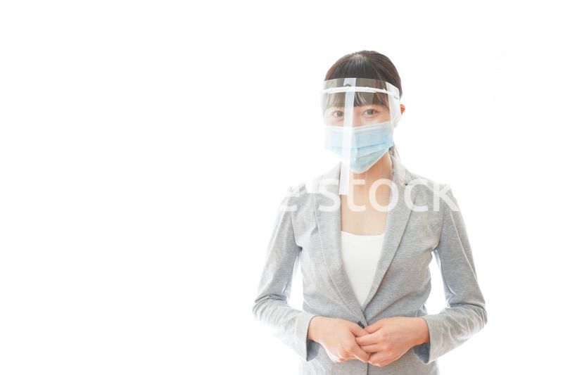 フェイスシールドをして働く若いビジネスウーマン