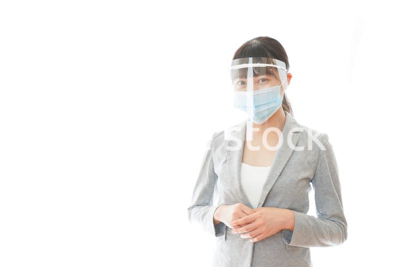 フェイスシールドをして働く若いビジネスウーマン