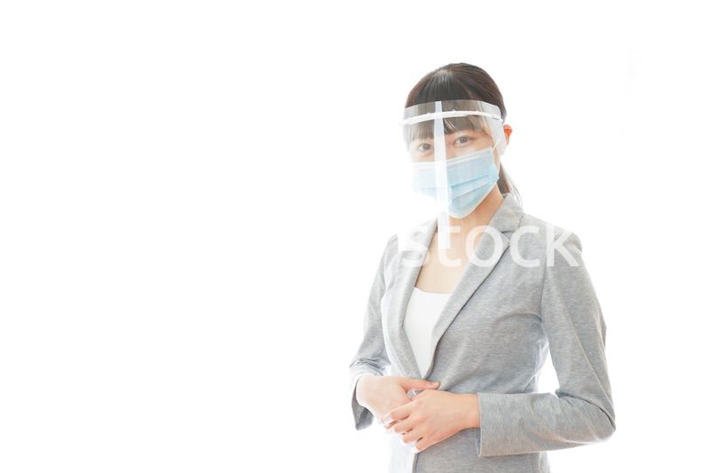 フェイスシールドをして働く若いビジネスウーマン