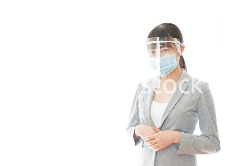 フェイスシールドをして働く若いビジネスウーマン