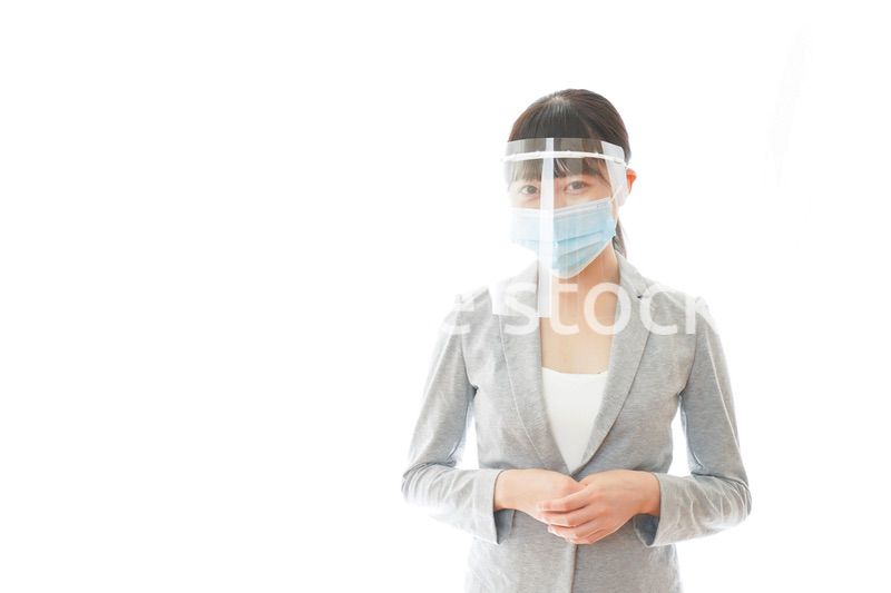 フェイスシールドをして働く若いビジネスウーマン