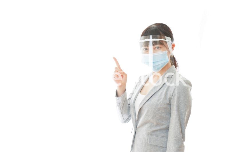 フェイスシールドをしてポイントを指差す若いビジネスウーマン