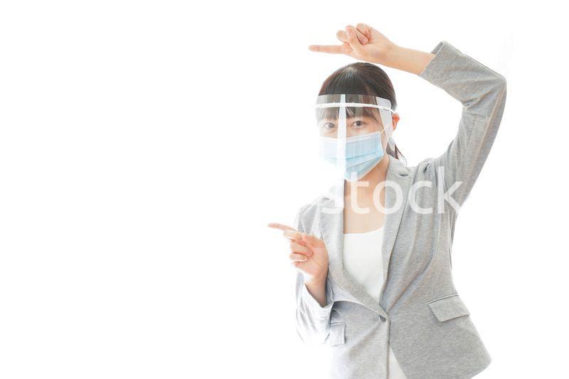 フェイスシールドをしてポイントを指差す若いビジネスウーマン