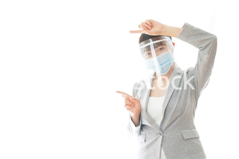 フェイスシールドをしてポイントを指差す若いビジネスウーマン