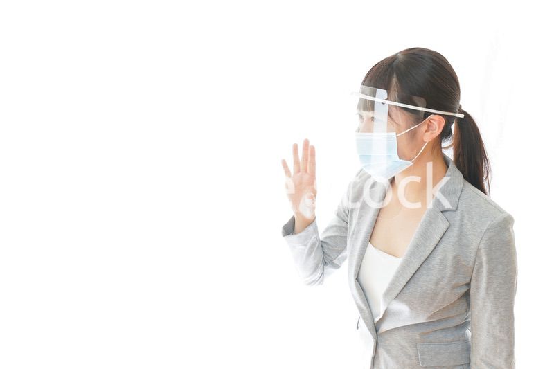 フェイスシールドを装着して接客をするビジネスウーマン