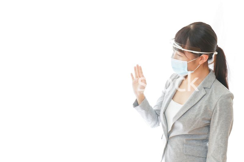 フェイスシールドを装着して接客をするビジネスウーマン