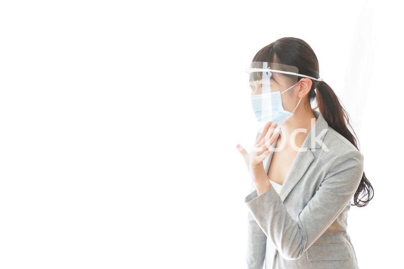 フェイスシールドを装着して接客をするビジネスウーマン