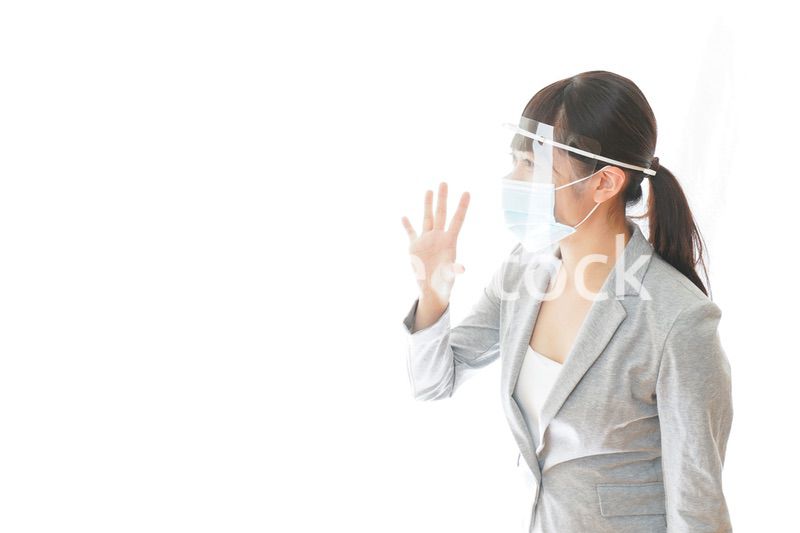 フェイスシールドを装着して接客をするビジネスウーマン