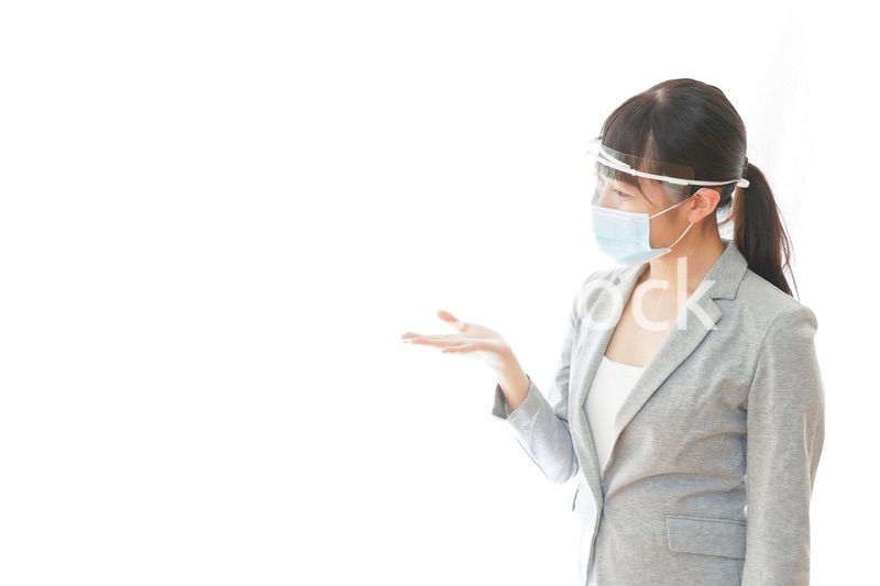 フェイスシールドを装着して接客をするビジネスウーマン