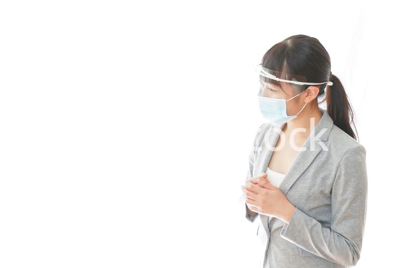 フェイスシールドを装着して接客をするビジネスウーマン