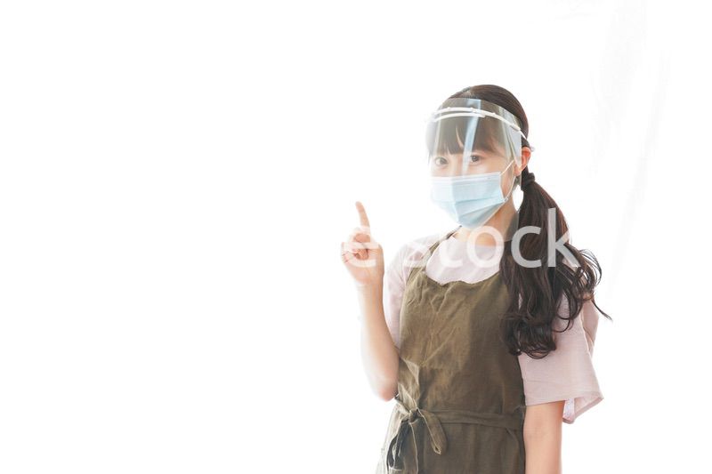 フェイスシールドを装着して指をさすカフェスタッフ