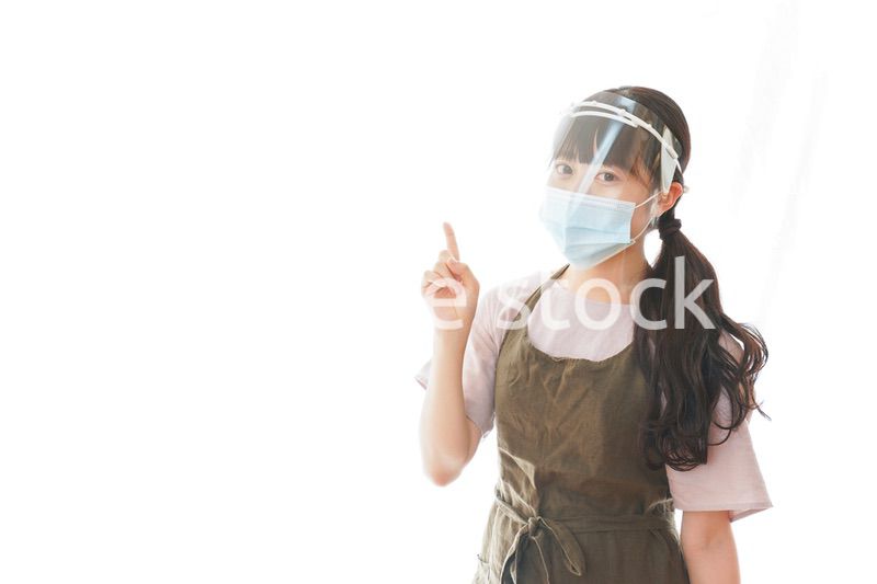 フェイスシールドを装着して指をさすカフェスタッフ