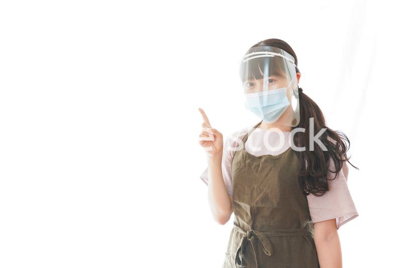 フェイスシールドを装着して指をさすカフェスタッフ