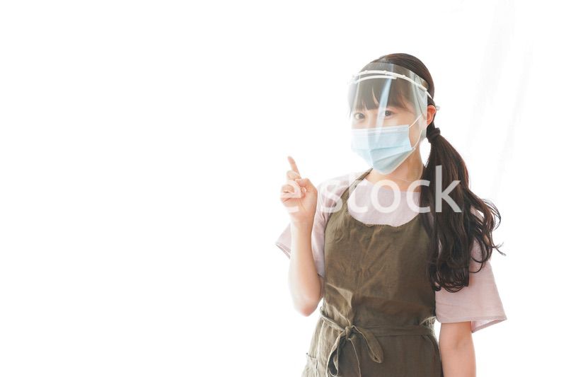 フェイスシールドを装着して指をさすカフェスタッフ