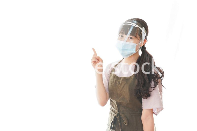 フェイスシールドを装着して指をさすカフェスタッフ