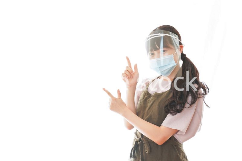 フェイスシールドを装着して指をさすカフェスタッフ